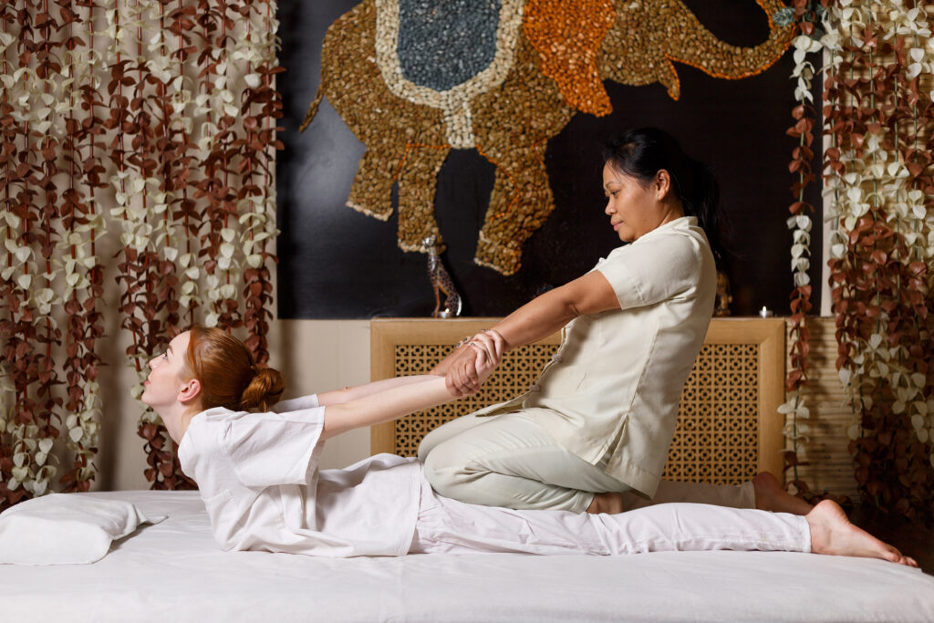 Frau massiert Kundin mit traditioneller Thai Massage